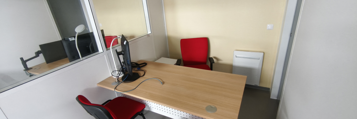 Bureau avec table, chaises, support pour ordinateur portable et radiateur.