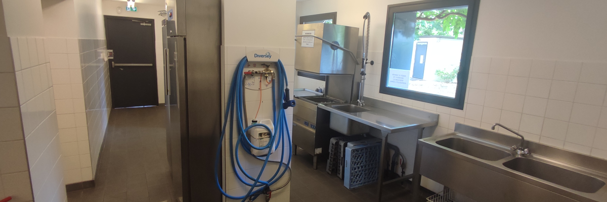 Laboratoire avec appareil à gaz, évier, porte et fenêtre.