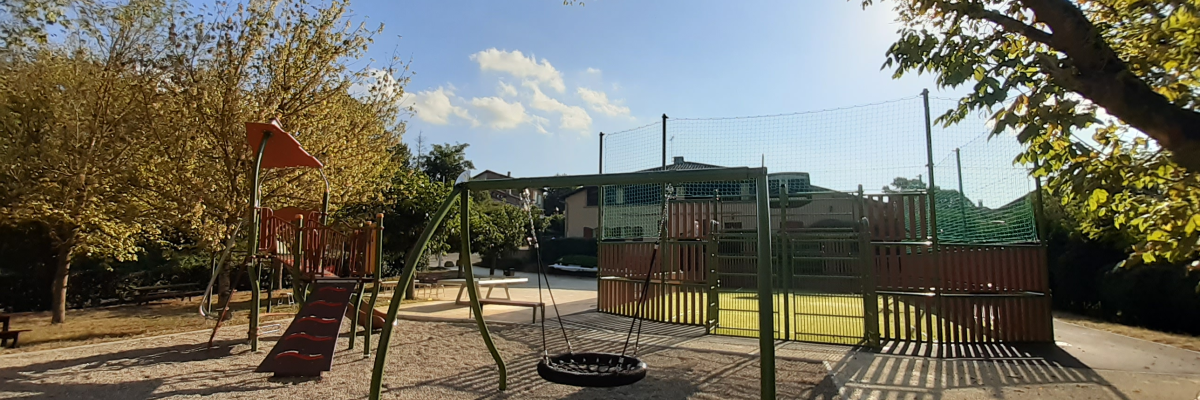 Aire de jeux avec toboggan, balançoire, tourniquet et bancs.