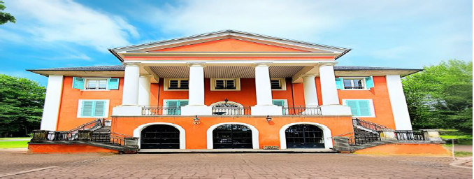 Bâtiment orange avec colonnes et escaliers.