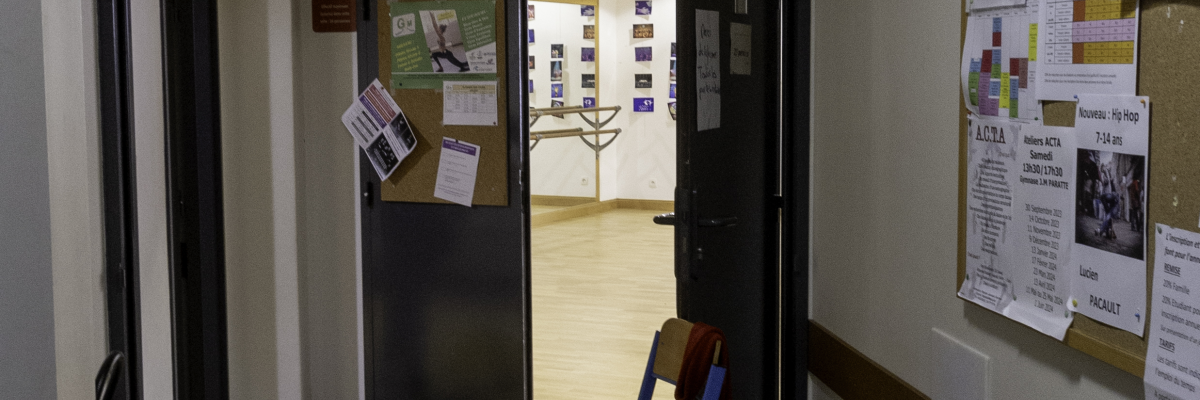 Couloir avec porte, chaise, tapis et affiches.