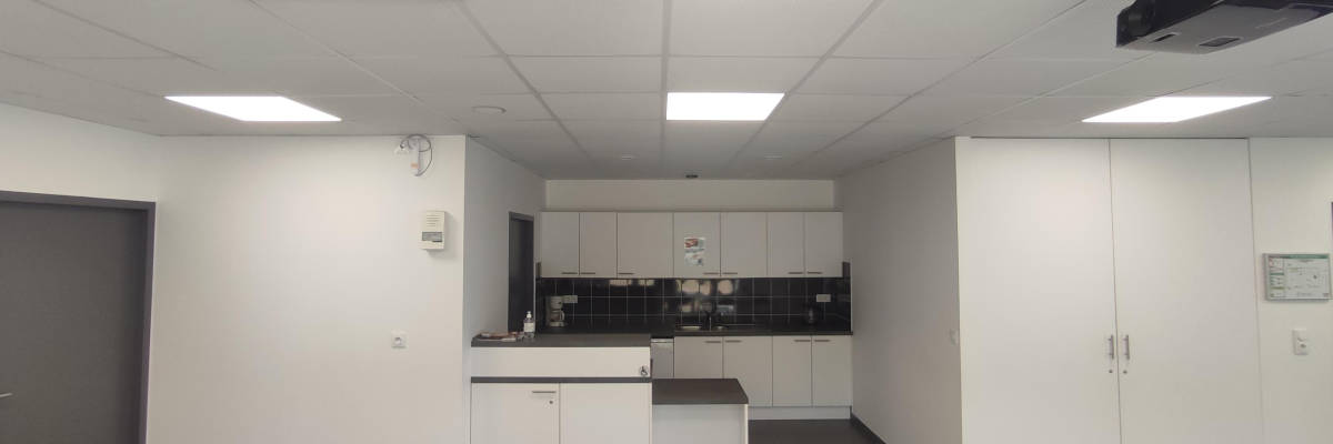 Cuisine avec placards, plan de travail, évier, machine à café et videoprojecteur.