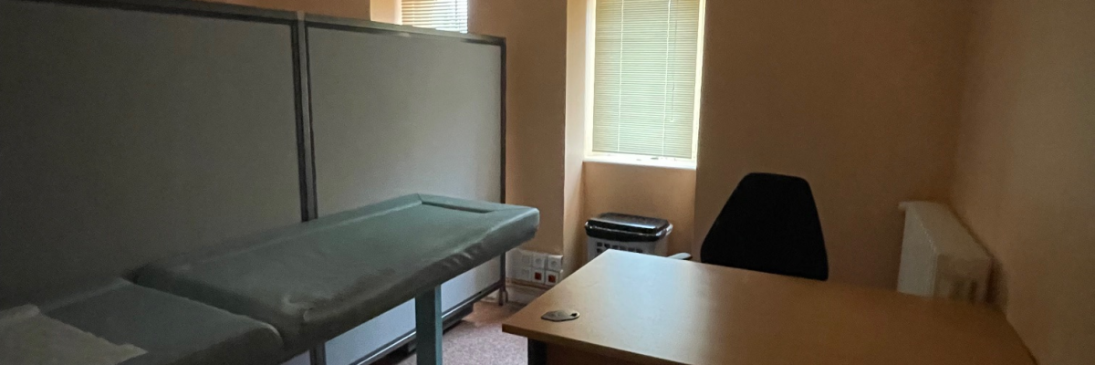 Bureau avec table, chaise, écrans et fenêtre.