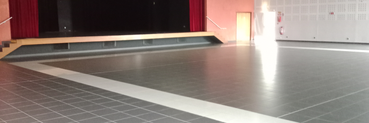 Salle avec scène, projecteurs et murs colorés.