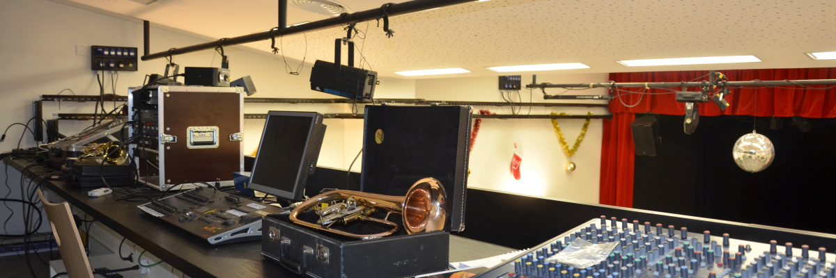 Studio équipé d'une table de mixage, amplis, haut-parleurs, instruments et casques audio.