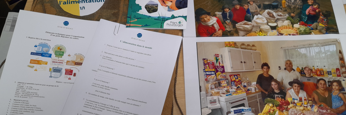 Sur une table, brochures, photos, et documents sur l'alimentation et les producteurs locaux.