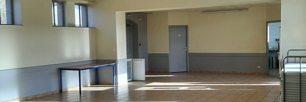 Salle avec table, chaises, chariot, penderie et plafonnier.