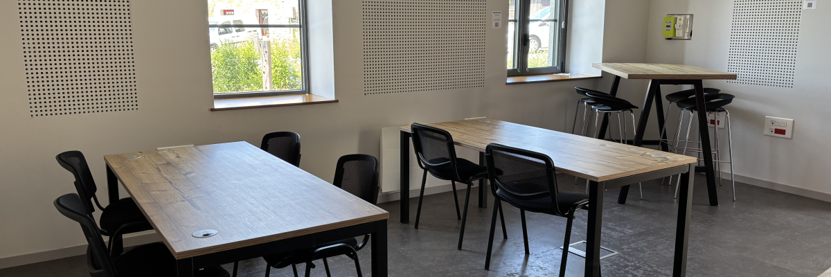 Salle avec deux tables, chaises, et tabourets de bar.