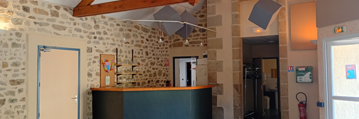 Hall avec comptoir, portes, tableau blanc, extincteur, et structure en bois.