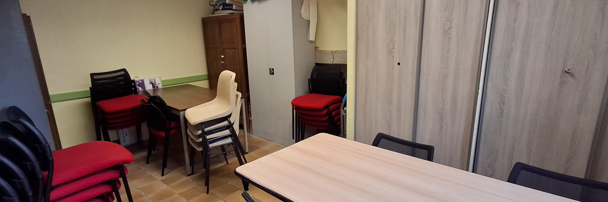 Pièce avec table, chaises, placard, étagères, porte-manteau.