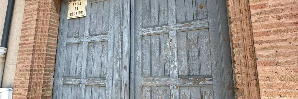 Porte en bois usée avec encadrement en brique.