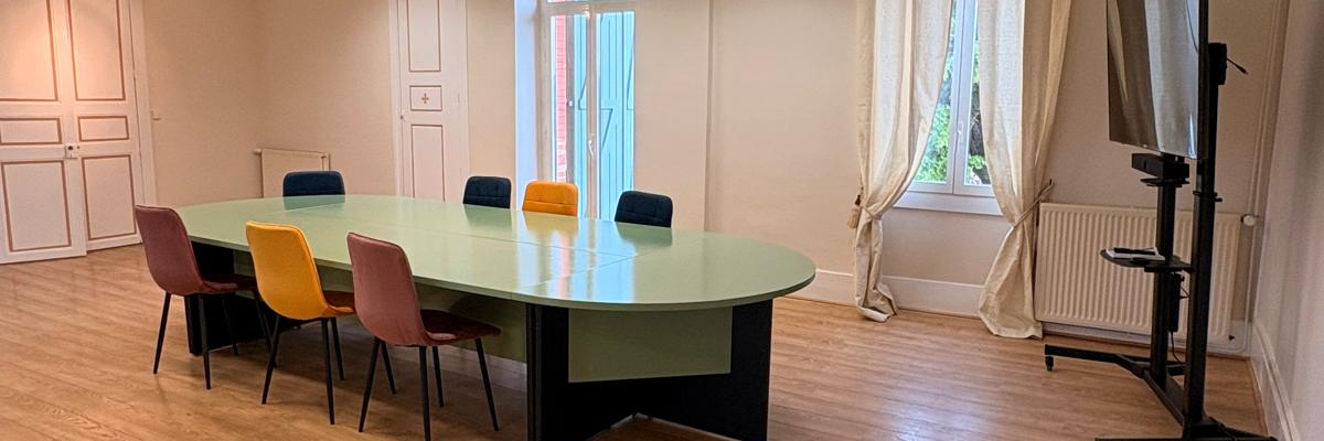 Salle avec table, chaises, téléviseur, radiateur et luminaires.