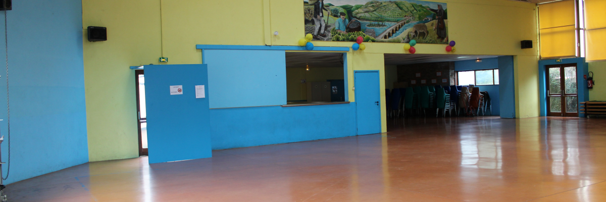 Salle avec comptoir, portes, chaises et table à l'arrière-plan.