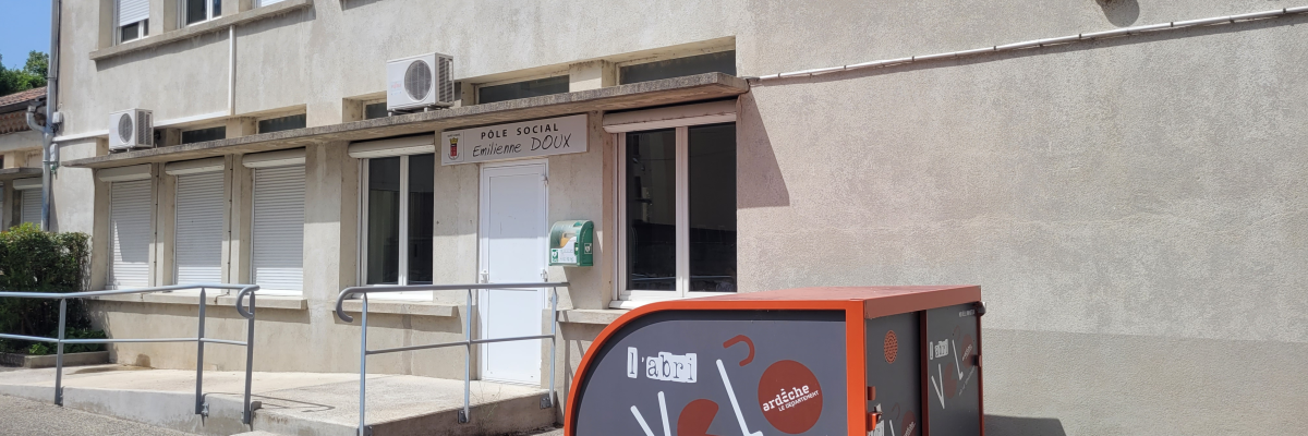 Bâtiment avec entrée, rampes, climatiseurs et structure Vélô devant.