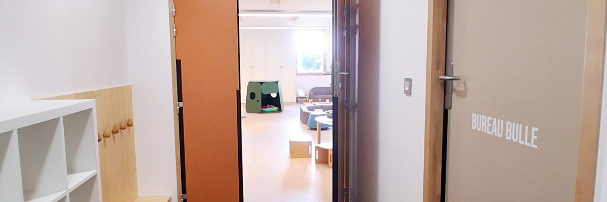 Couloir avec étagères, portes et salle visible au fond.