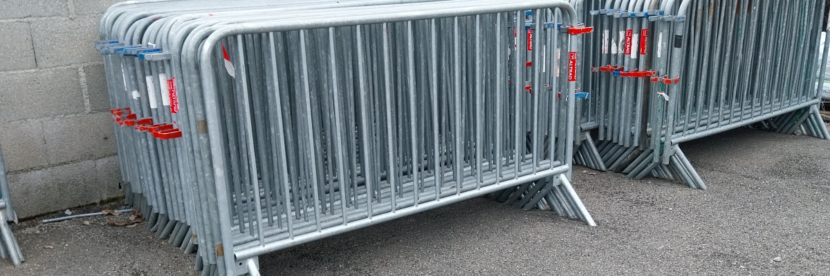 Barrières métalliques empilées contre un mur de briques.