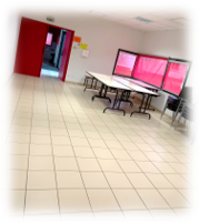 Salle avec tables, chaises, tableau et porte.