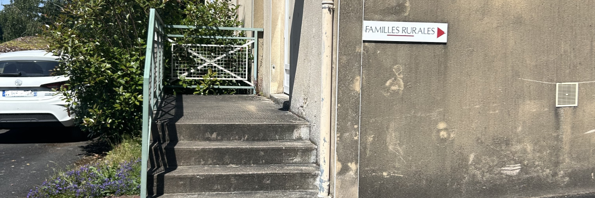 Bâtiment avec escalier, enseigne "Salle de la Mairie", voiture et arbre.
