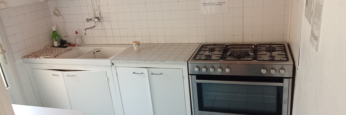 Cuisine avec évier, plan de travail, cuisinière, armoires et lave-vaisselle.