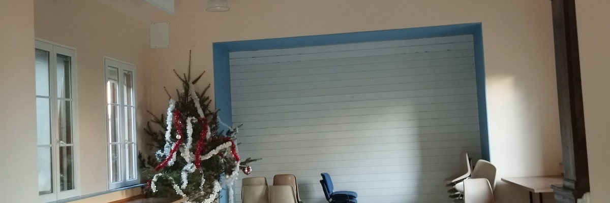 Salle avec tables, chaises, fleurs et portes.