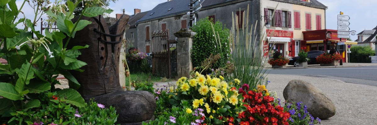 "Rond-point avec bottes, fleurs, pierres et bâtiments."