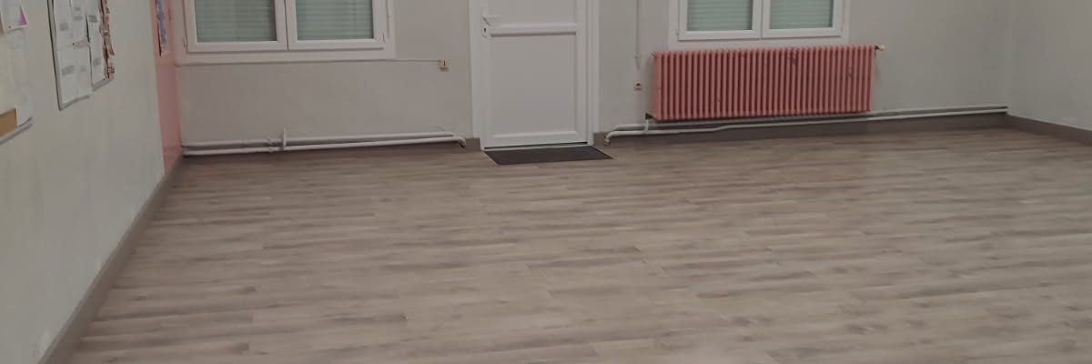 Pièce vide avec fenêtres, porte, radiateur et éclairage au plafond.