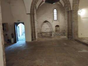 Pièce vide avec arches, voûtes et fenêtres.