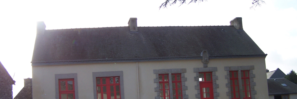 Maison avec toiture grise, murs blancs, fenêtres et portes rouges encadrées de gris, et cheminée.