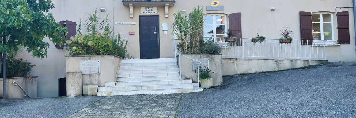 Mairie avec façade, volets, pots de fleurs, escalier et trottoir pavé.