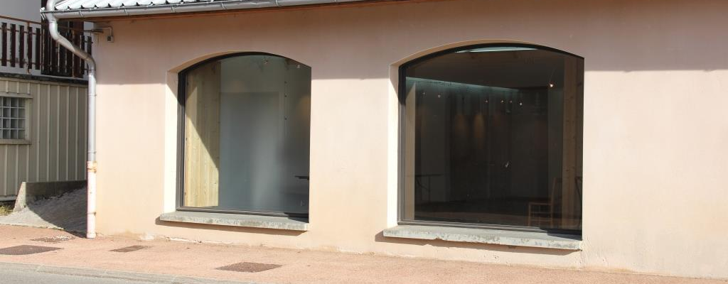 Bâtiment avec deux grandes fenêtres et une gouttière.
