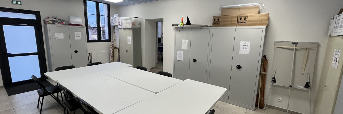 Salle avec table, chaises, armoires, étagères et porte.