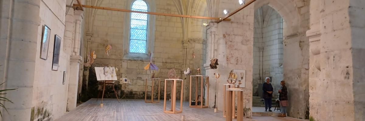 Salle avec scène, tableaux, échafaudages et projecteurs suspendus.