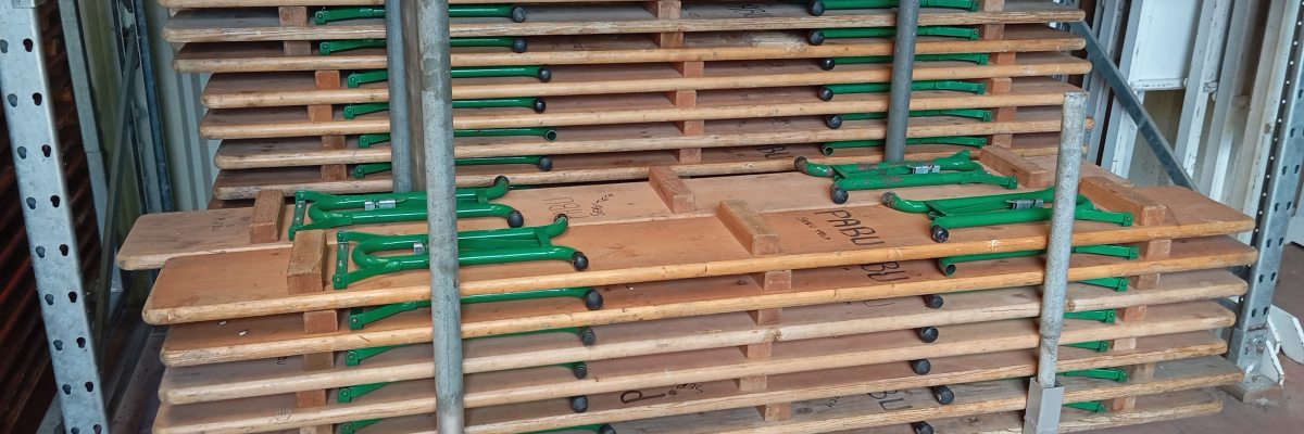 Palettes empilées sur chariot métallique à roulettes.