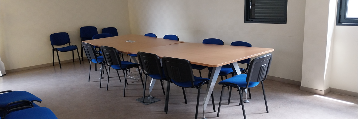 Salle avec table, chaises et fenêtre.