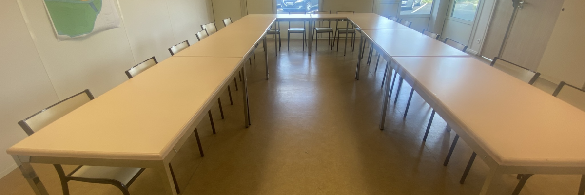 Salle avec tables, chaises, tableaux, œuvres d'art et fenêtres.