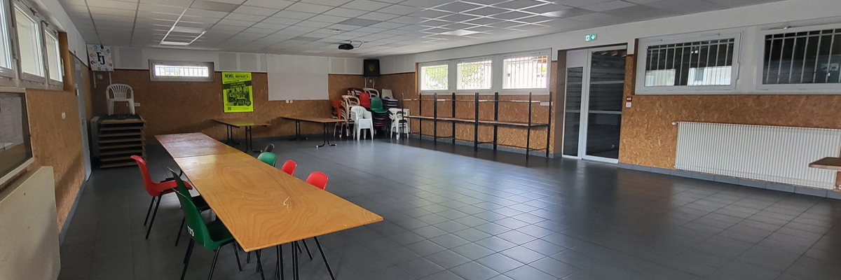 "Salle avec tables, chaises, radiateurs, placard, et affiche murale."