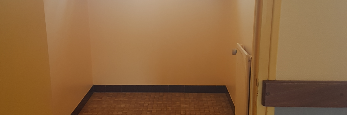 Petite salle de bain avec douche, lavabo, porte ouverte et serviettes accrochées.