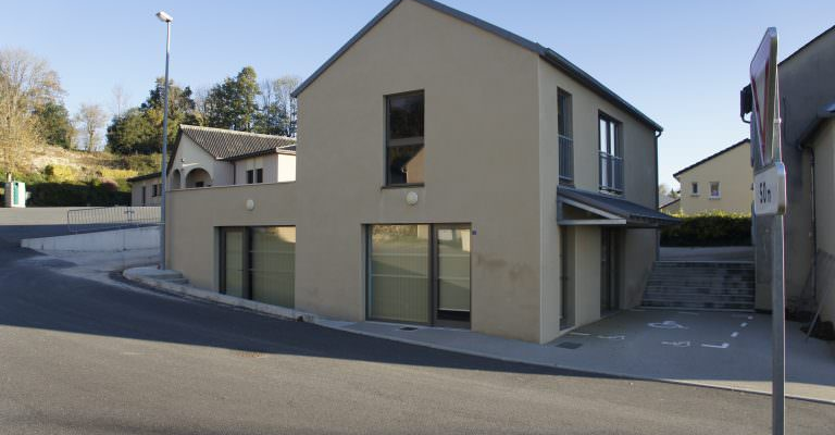 Maison moderne avec garage, fenêtres, porte et escalier menant à l’entrée.