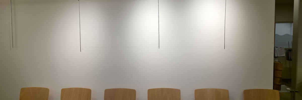 "Salle d'attente avec rangée de chaises en bois et éclairage suspendu".