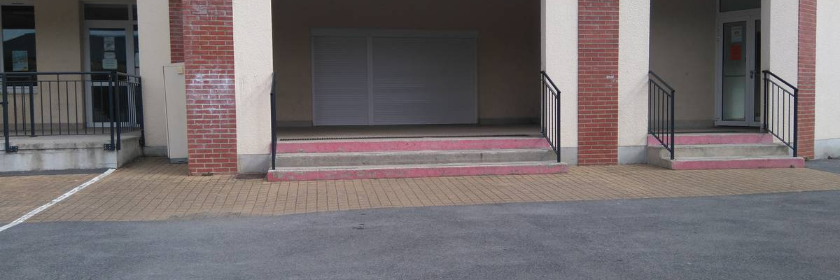 Entrée de garage avec deux rampes et un portail central.