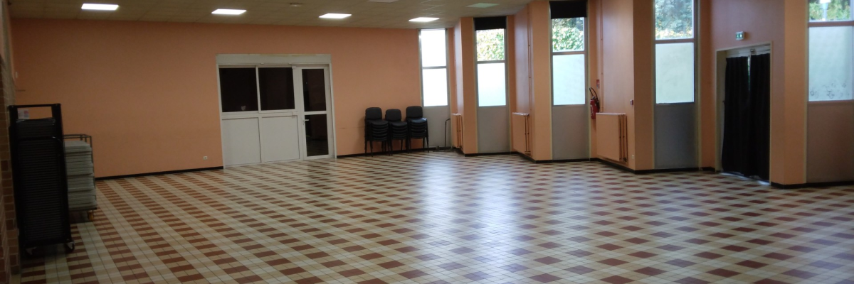 Salle vide avec sol carrelé, portes, fenêtres, ascenseur et chariot.