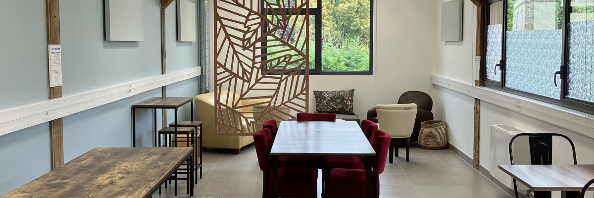 Salle avec tables, chaises, canapés et tabourets.