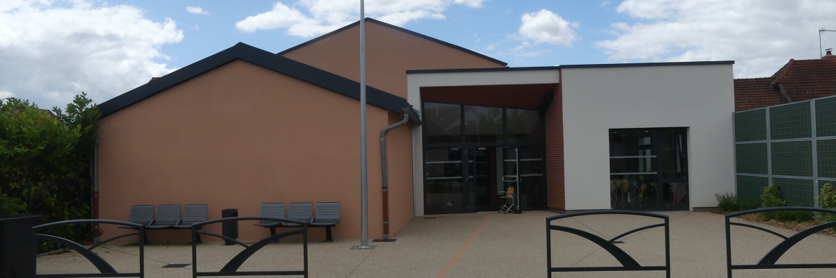 "Bâtiment avec entrées, bancs, lampadaire et chemin piétonnier."