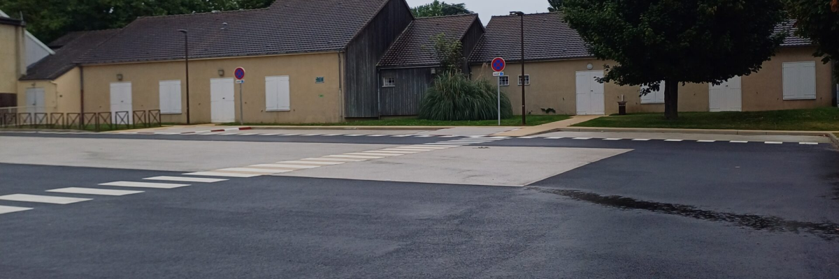 Enseigne avec parking, bâtiments résidentiels, arbres.
