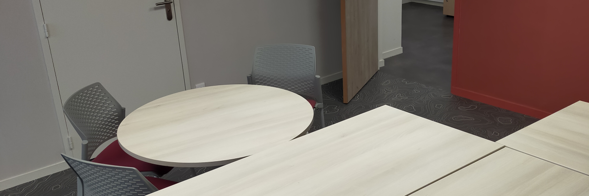 Salle avec tables, chaises, portes et mur rouge.