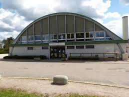 Bâtiment industriel avec entrée principale et grandes fenêtres.