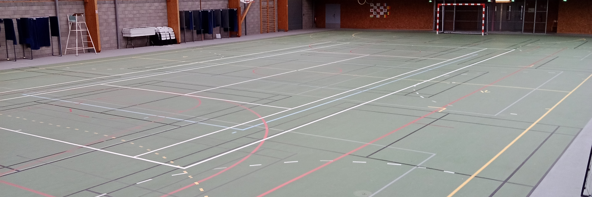Salle de sport avec terrain de basket et lines de tennis.