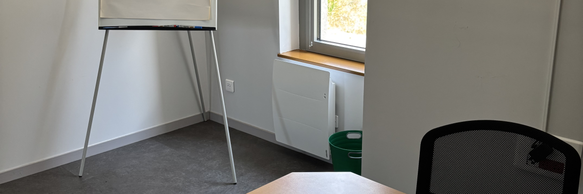Table, chaises et paperboard dans une salle.