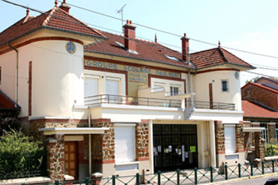 "Bâtiment avec enseigne, fenêtres, portes et toiture en tuiles rouges."