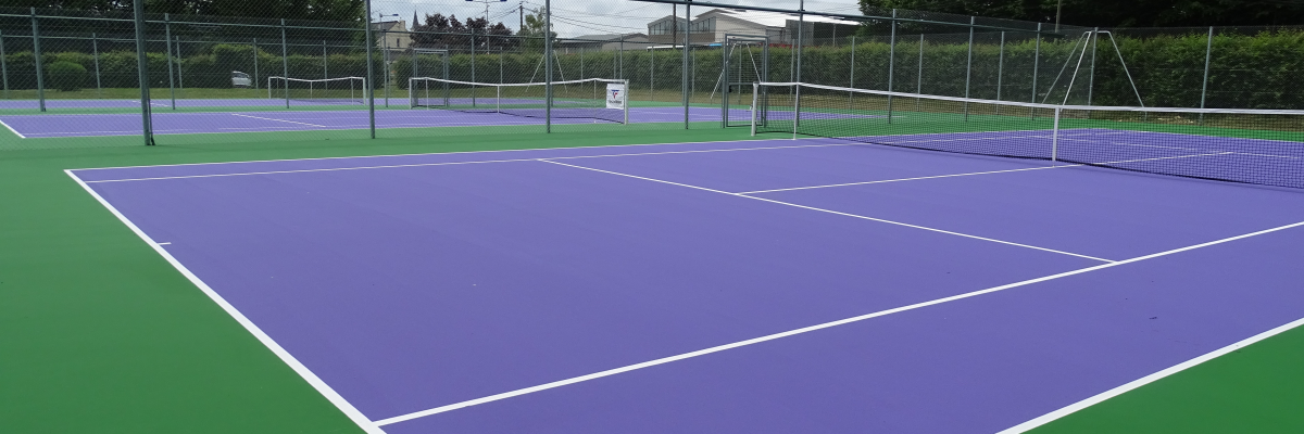 Terrain de tennis avec filet et clôture.